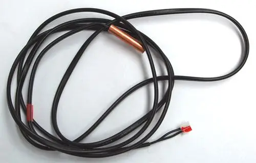 Daikin Fühler mit zwei schwarzen Kabeln, einem roten Stecker und einem metallischen Element in der Mitte. Das Kabel ist aufgewickelt und auf einem weißen Hintergrund.
